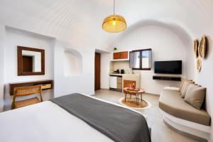 a hotel room with a bed and a couch at Santorini Rooftop Hot Tub Suite with Panoramic Views in Akrotiri