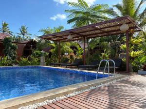 a swimming pool with a pergola next to a resort at Artala Villa & Restaurant in Besakih