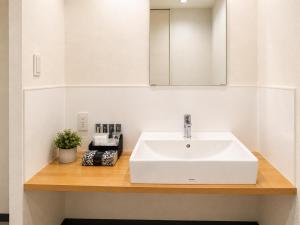 a bathroom with a white sink and a mirror at MrKINJO in Air Resort in Hirara