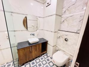 a bathroom with a sink and a toilet and a mirror at Southern Stays in New Delhi