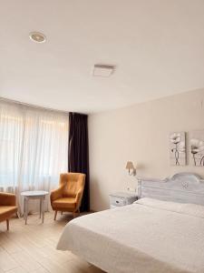 a bedroom with a bed and a chair and a table at Aparthotel Bahia Pinosol in Jávea +104 photos
