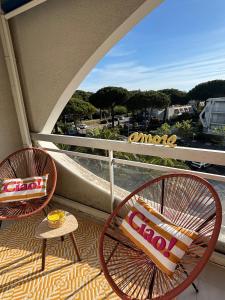 two chairs and a table on a balcony at Studio cabine parking 4 pers plage à proximité in La Grande Motte