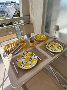 a table with plates and utensils on it at Studio cabine parking 4 pers plage à proximité in La Grande Motte