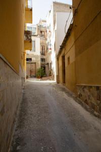 an empty street in an alley between buildings at La Casa Sotto il Campanile in Sciacca