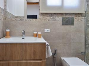 a bathroom with a sink and a toilet at La Casa Sotto il Campanile in Sciacca +8 photos