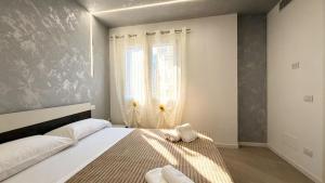 a bedroom with a large bed with towels on it at Casa LIAM & Casa ISABEL in Chioggia
