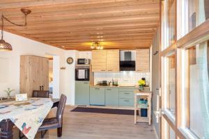 a kitchen with blue cabinets and a table in a room at Fewo Enzian in Breitenberg
