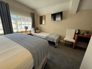 a hotel room with two beds and a desk at The Olde Kings Arms in Hemel Hempstead