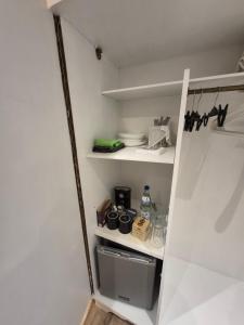 a small kitchen with white shelves in a room at Reinecke Fuchs in Bad Münder am Deister