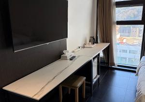 a desk in a hotel room with a television on the wall at Wolmido Premiers Hotel in Incheon