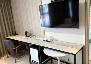 a hotel room with a desk with a television on the wall at Wolmido Premiers Hotel in Incheon