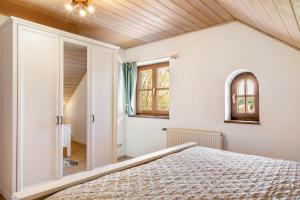 a bedroom with white walls and a wooden ceiling at Fewo Enzian in Breitenberg