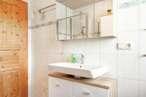 a bathroom with a sink and a mirror at Fewo Enzian in Breitenberg +15 photos