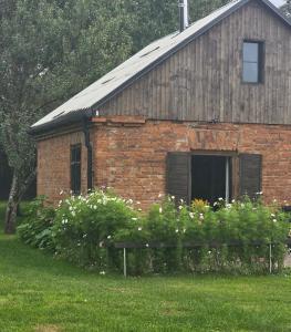 a brick building with a window and some flowers at Žemosios Panemunės dvaro sodininko namas in Žemoji Panemunė +5 photos
