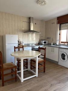 a kitchen with a table and chairs and a kitchen with a stove at Casa Vazan in Laguna Dalga