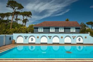 a house with a swimming pool in front of a house at Knoll House in Studland