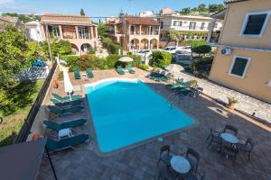 an overhead view of a swimming pool in a courtyard with chairs at Ariti Apartments in Kassiopi +17 photos
