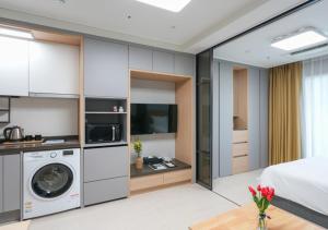 a bedroom with a bed and a washer and dryer at Firstcity Hotel YEOSU in Yeosu