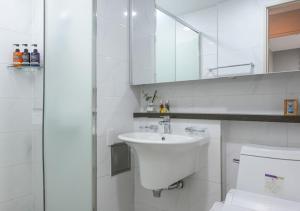 a white bathroom with a sink and a toilet at Firstcity Hotel YEOSU in Yeosu +35 photos