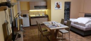 a small kitchen with a table and a bed at Apartmány-Včelka in Trpnouze