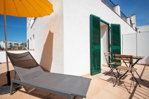 a patio with a chair and an umbrella and a table at Hotel Caleta in Lloret de Mar