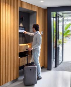 a man standing next to a piano with a suitcase at Zoku Amsterdam in Amsterdam +63 photos