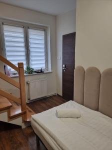 a room with a bed and a staircase and a window at Orzechowy Dom in Trzebnica