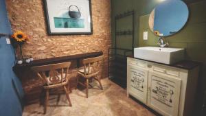a bathroom with a sink and a counter with two chairs at Bonfarto Locations in Urval