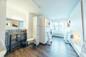 a bathroom with white cabinets and a fireplace at Hostel by Hyve Basel in Basel