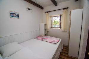 a small room with two beds and a window at Apartments Punta Blue & Orange 5 m from the sea in Punta Križa