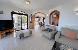 a living room with a couch and a flat screen tv at Casa Ronda in Charco del Palo