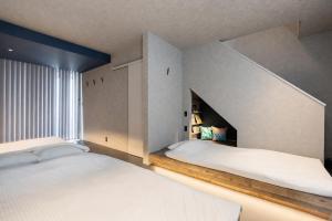 a bedroom with two beds and a window at nagisa awajishima in Awaji