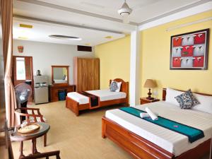 a hotel room with two beds and a bathroom at Sunny C Hotel in Hue