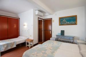 a hotel room with two beds and a desk at Hotel Caleta in Lloret de Mar