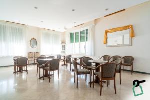 a dining room with tables and chairs and windows at Hotiday Lavagna Lungomare in Lavagna