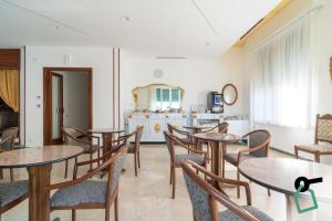 a dining room with tables and chairs and a kitchen at Hotiday Lavagna Lungomare in Lavagna
