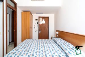 a bedroom with a bed with a blue and white comforter at Hotiday Lavagna Lungomare in Lavagna
