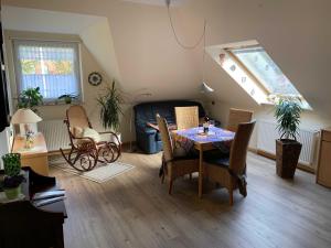 a living room with a table and chairs at "Haus Waldblick" in Bad Bramstedt +4 photos