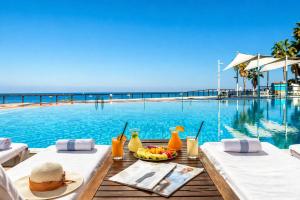 a table with a bowl of fruit next to a swimming pool at חדר על הים הרצליה in Herzliya B +4 photos