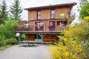 a wooden house with a table and an umbrella at Gite Nature Ressourcement-Vosges in Le Tholy