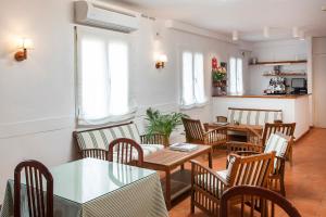 a restaurant with wooden tables and chairs and a table and chairsktop at Hotel Caleta in Lloret de Mar