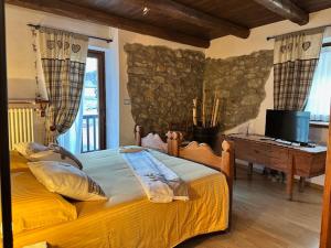 a bedroom with two beds and a desk in a room at La Peiro Douco in Roure Turin