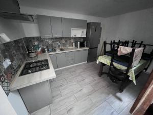 a small kitchen with a stove and a chair in it at Gospodarstwo Agroturystyczne E K Szabowscy in Jeżewo