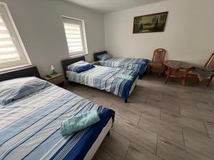 a bedroom with two beds and a table and chairs at Gospodarstwo Agroturystyczne E K Szabowscy in Jeżewo
