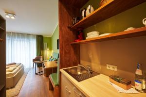a kitchen with a sink and a living room at Ferienanlage Kirchzarten in Kirchzarten