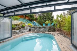 a swimming pool with a patio and a swimming poolvisor at Gite Nature Ressourcement-Vosges in Le Tholy