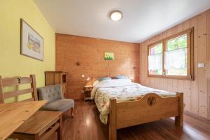 a bedroom with a bed and a table and a chair at Gite Nature Ressourcement-Vosges in Le Tholy +37 photos