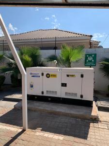 a white appliance sitting in front of a building at Executive Suites and Spa in Letlhakawe