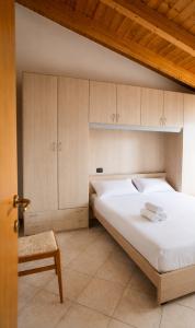 a bedroom with a large white bed and wooden cabinets at Carmel Self-Apartment in Castelnuovo del Garda +33 photos