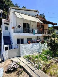 a large white house with a balcony and stairs at Domi's Cottage in Agia Triada